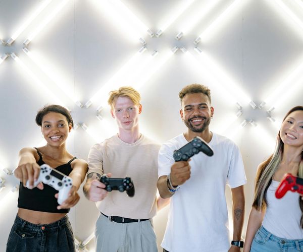 A diverse group of people smiling during a light yoga practice in a bright studio.